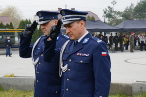 Komendanci Policji po złożeniu znicza oddają honor