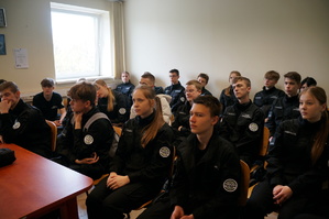 Uczniowie w sali odpraw raciborskiej policji słuchają wykładu policjanta o rekrutacji