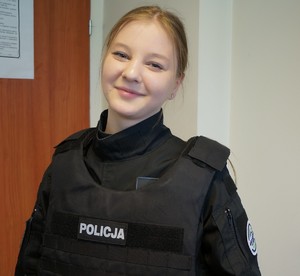 Uczennica prezentuje się w policyjnej kamizelce kuloodpornej