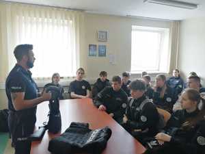 Policjant na sali omawia uczniom proces rekrutacji