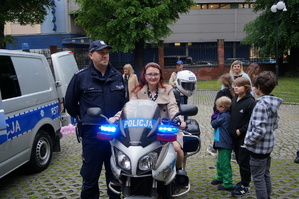 Dzieci i policjant przy policyjnym motocyklu