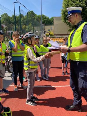 Policjant gratuluje uczniowi zdania na kartę rowerową