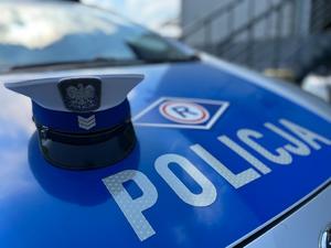 zdjęcie przedstawia radiowóz i czapkę policjanta