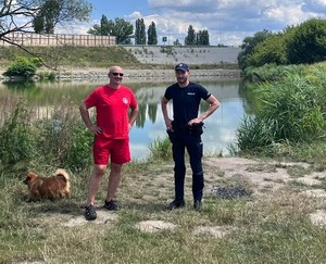 Na tle żwirowni policjant i ratownik wodnego ochotniczego pogotowia ratunkowego