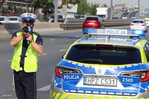 Policjant na tle radiowozu