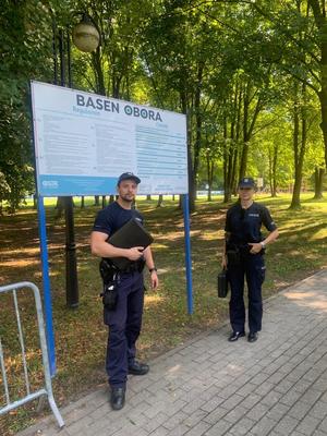 Wspólne zdjęcie policjantów na tle banneru na basenie