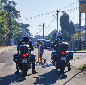 policjanci na motocyklach i dzieci na przejściu