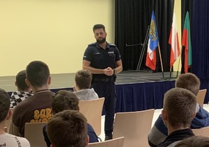 na zdjęciu policjant z uczniami