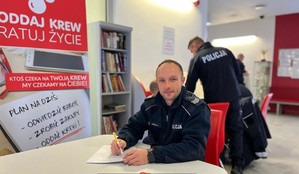 na zdjęciu policjant wypełniający dokumentację