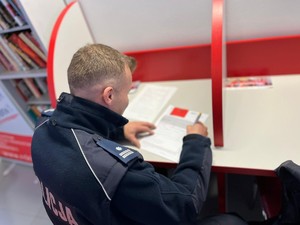 na zdjęciu policjant wypełnia ankietę