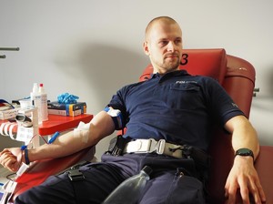 na zdjęciu policjant podczas poboru krwi
