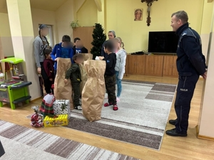 NA ZDJĘCIU DZIACI ROZPAKOWUJĄ PACZKI