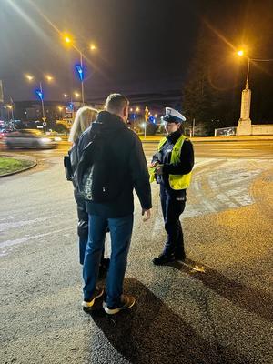 na zdjęciu policjant rozdaje odblaski