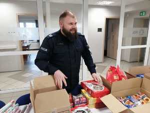 na zdjęciu policjant pakuje paczki świąteczne