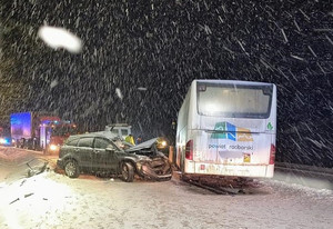 Zdjęcie z miejsca wypadku drogowego. Na zdjęciu autobus i zniszczony samochód osobowy.