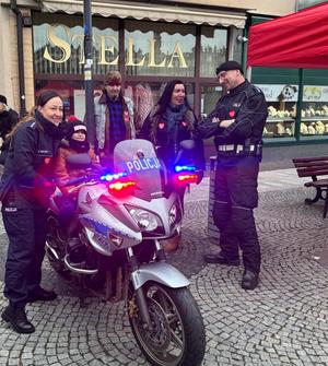 na zdjęciu motocykl i policjantka i policjant z serduszkiem na mundurze