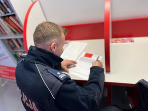 na zdjęciu komendant policji Marek Ryszka wypisuje formularz żeby oddać krew