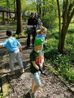 na zdjęciu Policjanci i dzieci sprzątają park