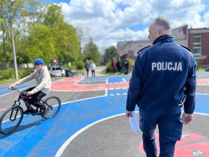 na zdjęciu uczeń pokonuje tor przeszkód a policjant patrzy