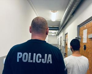 na zdjęciu mężczyzna z policjantem stoją tyłem