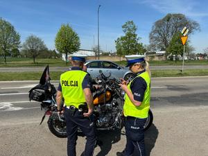 na zdjęciu policjant i policjantka kontrolują motocykl