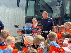 na zdjęciu policjant pokazuje motocykl