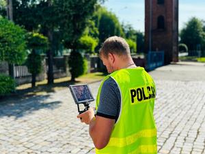 na zdjęciu policjant operujący dronem