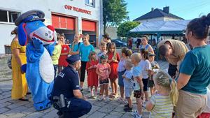 na zdjęciu policjant sznupek i dzieci rozmawiają