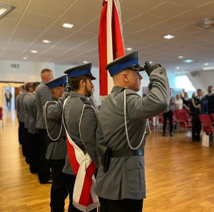 na zdjęciu policjanci stoją ze sztandarem