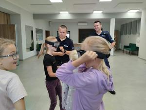 na zdjęciu policjanci pokazują alkogogle dzieciom j