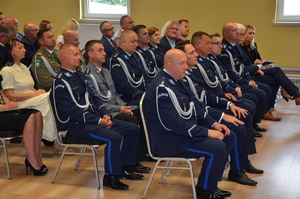 na zdjęciu policjanci i goście siedzą na krzesłach