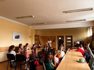 na zdjęciu policjant i przedstawicielka sanepidu rozmawiają z dziećmi