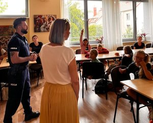 na zdjęciu policjant opowiada dzieciom o bezpieczeństwie