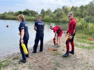 na zdjęciu policjanci rzucają rzutką do osoby