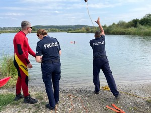 na zdjęciu policjant rzucający rzutką