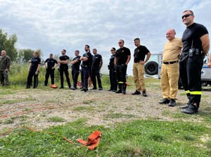 na zdjęciu policjanci i strażacy obserwujący ćwiczenia prowadzone przez wopr