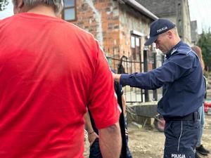 na zdjęciu policjanci rozdają potrzebne rzeczy powodzianom