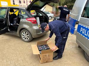 na zdjęciu policjanci rozdają potrzebne rzeczy powodzianom