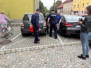 na zdjęciu policjanci pakują do auta panu agregat prądotwórczy