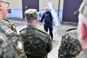 na zdjęciu policjant tłumaczy funkcjonariuszom straży granicznej tworzenie pododdziałów zwartych