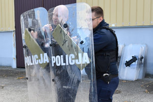 na zdjęciu policjanci pokazują trzymanie tarczy