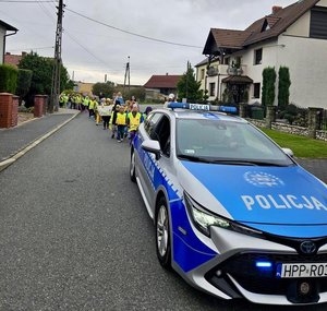 na zdjęciu radiowóz pilotuje dzieci w odblaskach