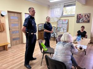 na zdjęciu policjant i policjantka prowadza wykład odnośnie bezpieczeństwa seniorzy siedzą w ławkach