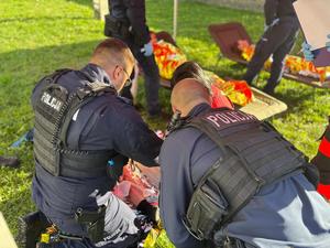 na zdjęciu policjanci pomagają poszkodowanym