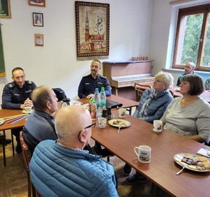 na zdjęciu policjanci z seniorami przy stole