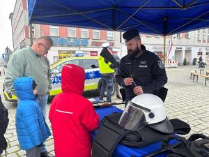 na zdjęciu policjant pokazują sprzęt policyjny dzieciom i dorosłym