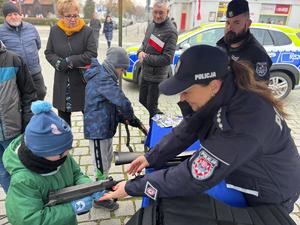 na zdjęciu policjantka pokazuje sprzęt policyjny