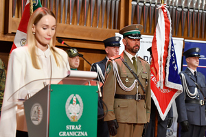 na zdjęciu prowadząca spotkanie kobieta w białej bluzce przy mikrofonie