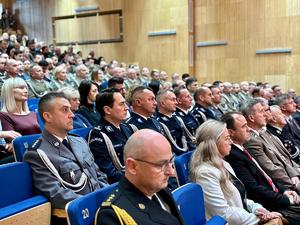 na zdjęciu siedzący zastępca komendanta i mundurowi z policji