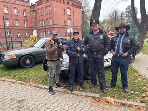 na zdjęciu policjantka pozująca do zdjęć z przebranymi policjantami z innych krajów